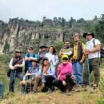 山の中で11人が2列に並んでポーズをとっている