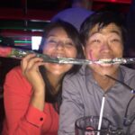 メキシコの観光ガイド岩﨑功が妻と一緒にバラを咥えて笑っている