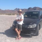 メキシコの観光ガイド岩﨑功がラパスで車の前で腕を組んで立っている