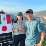 女二人男一人が雄大なサボテンの渓谷を背景に立っている