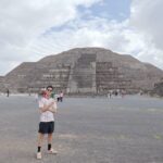 ピラミッドを背景にポーズをとる男性