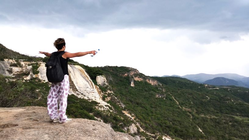 Kazutosan - メキシコのプライベートツアー | MCT 男性が谷方面を見て両手を広げて風を感じている